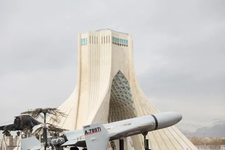 Drone și rachete expuse în fața unei clădiri emblematice din Iran.