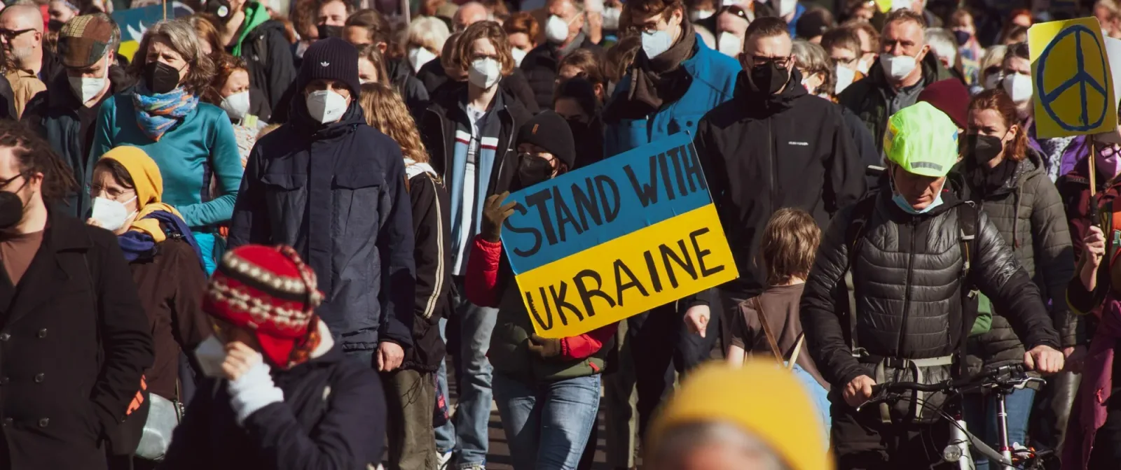 Oameni protestând pentru susținerea Ucrainei într-un oraș aglomerat.