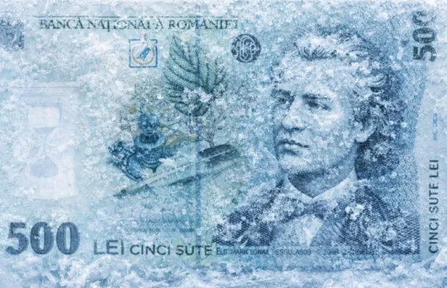 Bancnotă de 500 lei acoperită cu gheață, simbolizând volatilitatea economică.