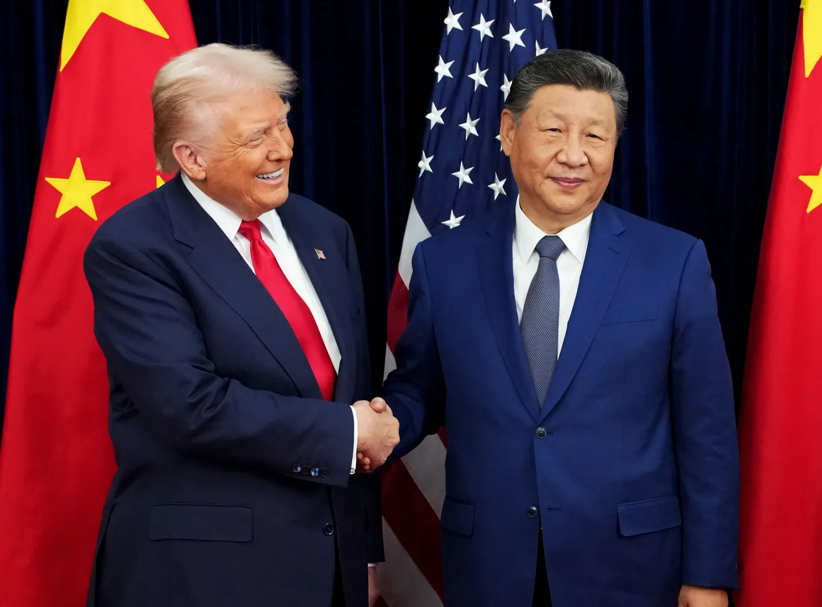 Donald Trump și Xi Jinping strâng mâna în cadrul unei întâlniri oficiale.