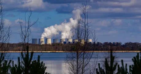 Centrale pe cărbune în peisajul german, cu fum alb ieșind din chimene.