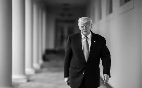 Donald Trump mergând pe un coridor, cu o expresie serioasă.