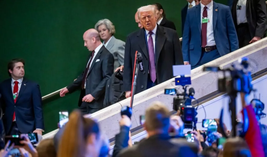 Donald Trump înconjurat de jurnaliști la un eveniment public.