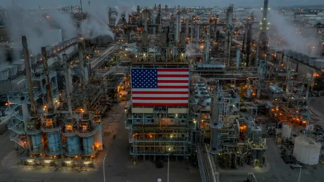 O rafinărie de petrol iluminată, cu steagul american pe clădire.