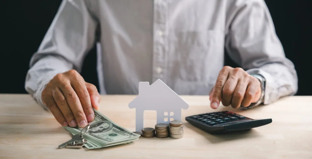 Persoană analizând costurile financiare cu bani și un calculator.