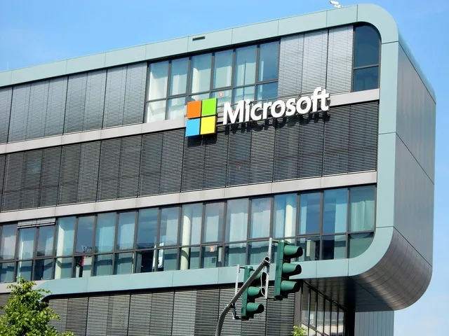 Clădirea Microsoft cu logo-ul companiei pe fațadă, sub un cer senin.