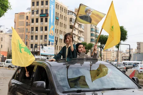 Copii cu steaguri Hezbollah pe un automobil în orașul Liban.