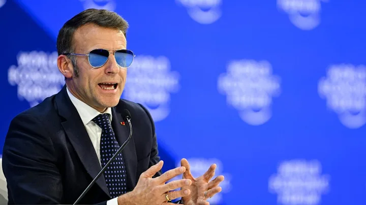 Emmanuel Macron discutând despre tensiunile comerciale cu SUA la un eveniment internațional.