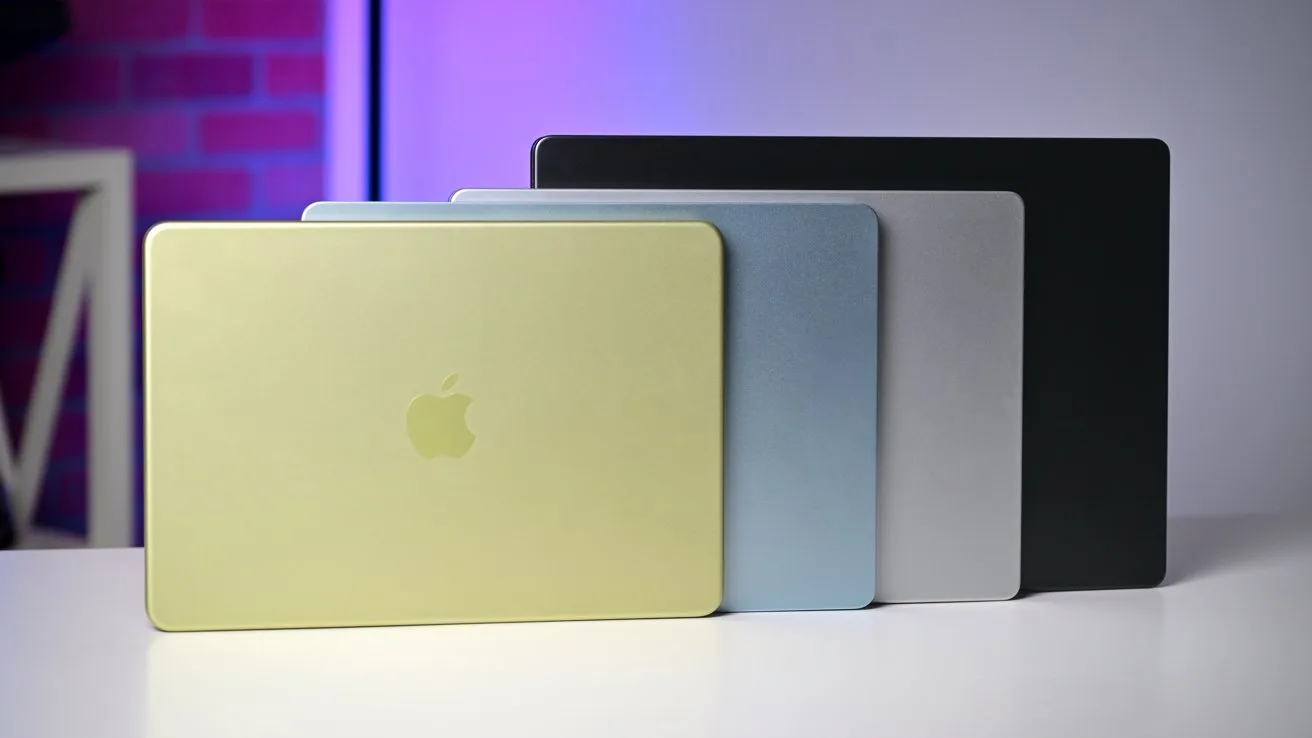 Laptopuri Apple de diferite culori așezate pe o masă.