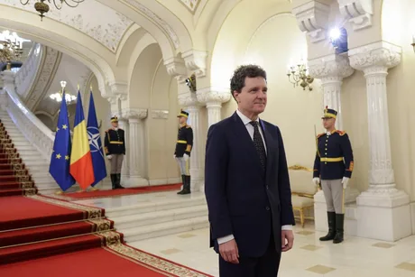Nicușor Dan în fața steagurilor Uniunii Europene și României.