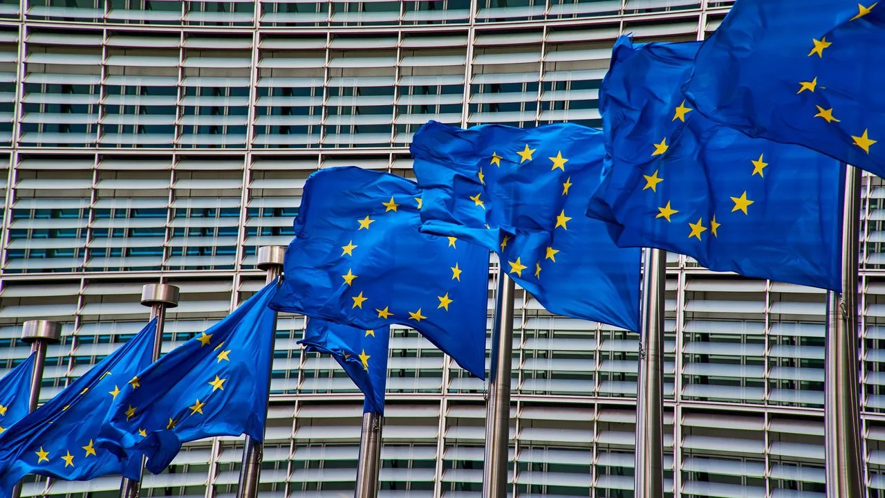 Steaguri ale Uniunii Europene fluturând în fața clădirii Comisiei Europene.