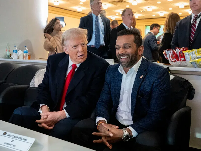 Kash Patel discută cu Donald Trump într-un mediu informal, zâmbind.