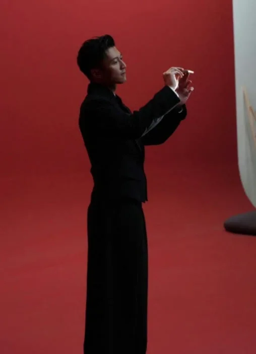 Nicholas Tse interacționează cu HONOR Magic V6 pe fundal roșu.