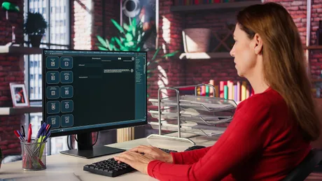 O femeie lucrează la un computer, analizând datele într-un mediu de birou modern.