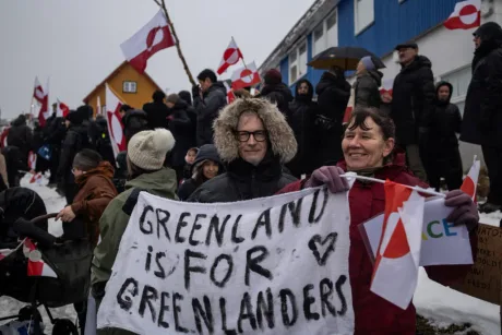Protestatari cu steaguri și pancarte în Nuuk.