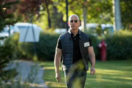 Jeff Bezos plimbându-se printr-un parc, purtând o vestă și ochelari de soare.