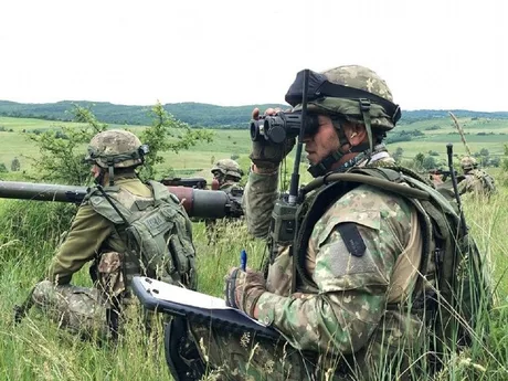 Soldați în teren, pregătiți pentru exerciții militare în natură.