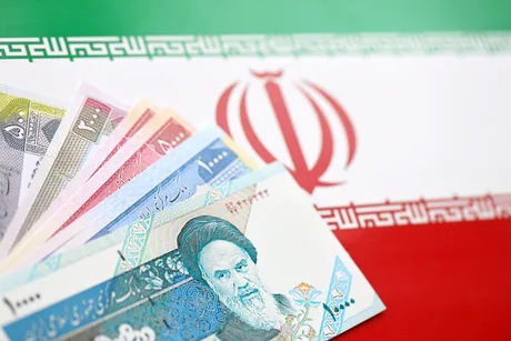 Bancnote iraniene pe fundalul steagului național al Iranului.