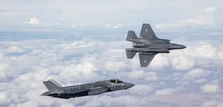 Avioane de luptă israeliene zburând deasupra norilor, pregătiri militare în curs.