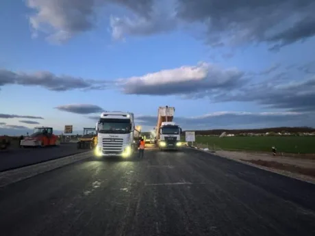 Lucrări pe Lotul 1 al Autostrăzii A0, cu utilaje și muncitori pe șantier.