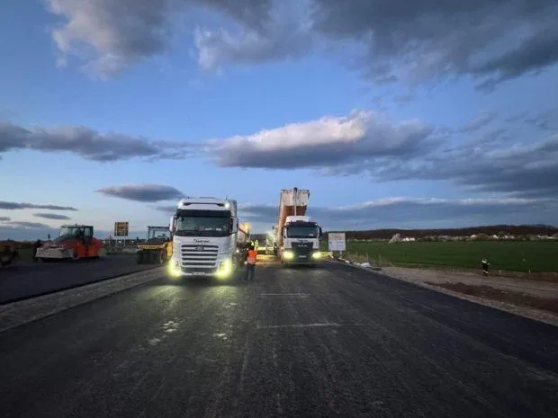 Lucrări pe Lotul 1 al Autostrăzii A0, cu utilaje și muncitori pe șantier.