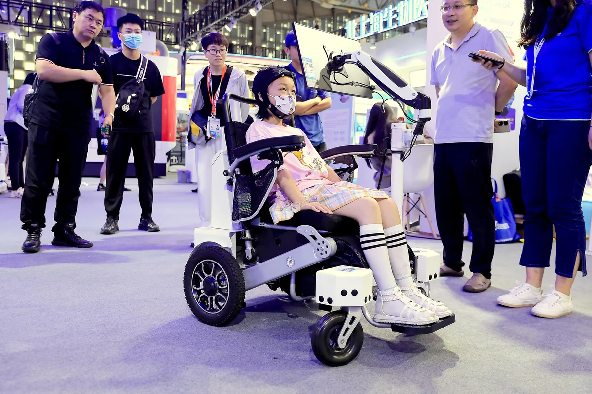 Un copil într-un scaun cu rotile avansat, demonstrând tehnologia BCI în China.