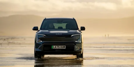 Un SUV electric Kia pe plajă, cu un design modern și elegant.