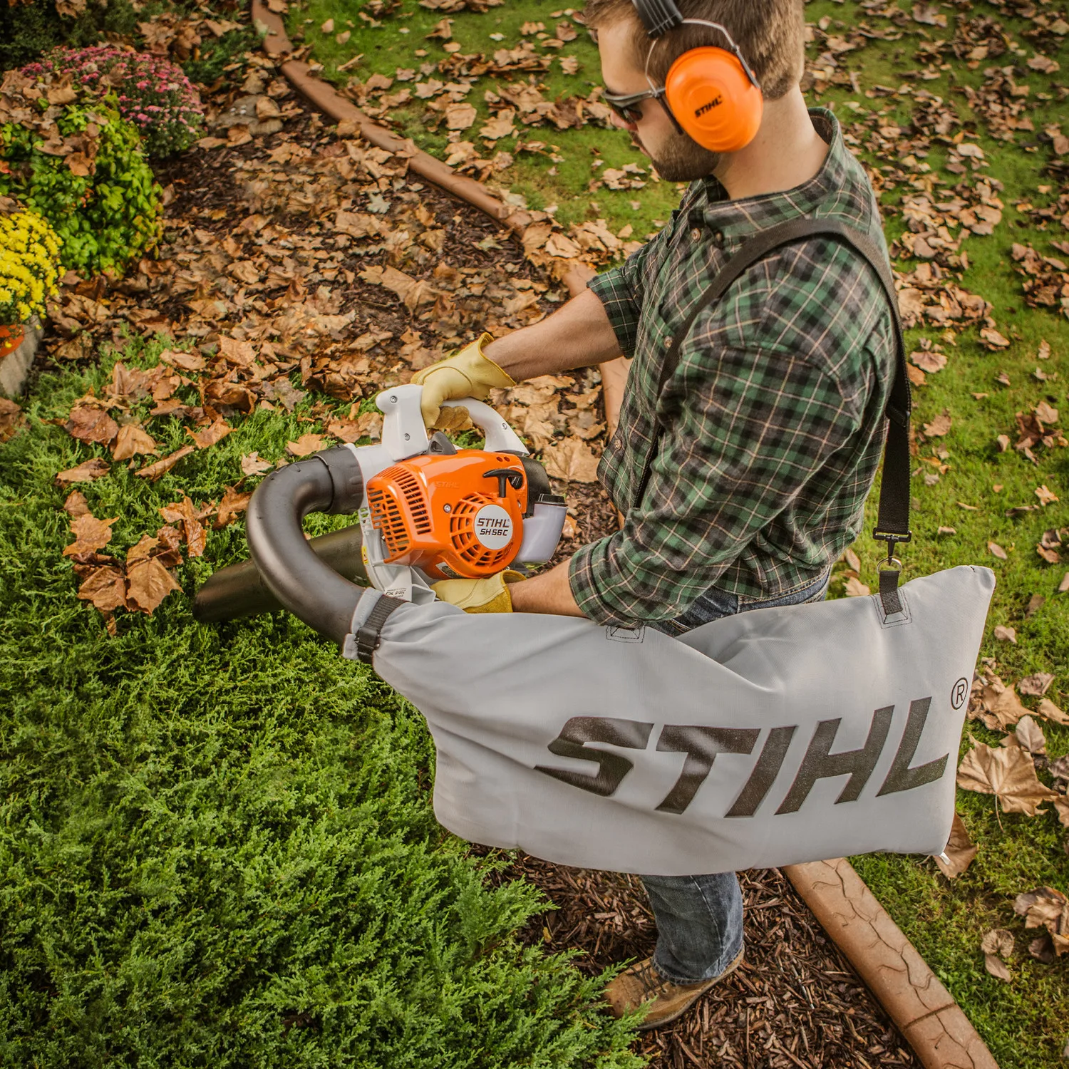 Un bărbat folosește un suflător de frunze STIHL în grădină.