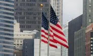Steaguri americane fluturând în fața clădirilor înalte din oraș.