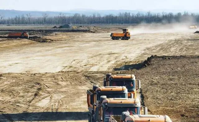 Teren pregătit pentru construcția Autostrăzii Moldovei, cu utilaje în acțiune.