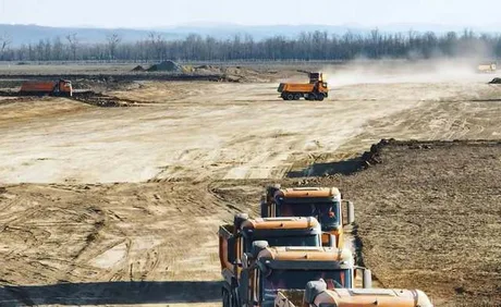 Teren pregătit pentru construcția Autostrăzii Moldovei, cu utilaje în acțiune.