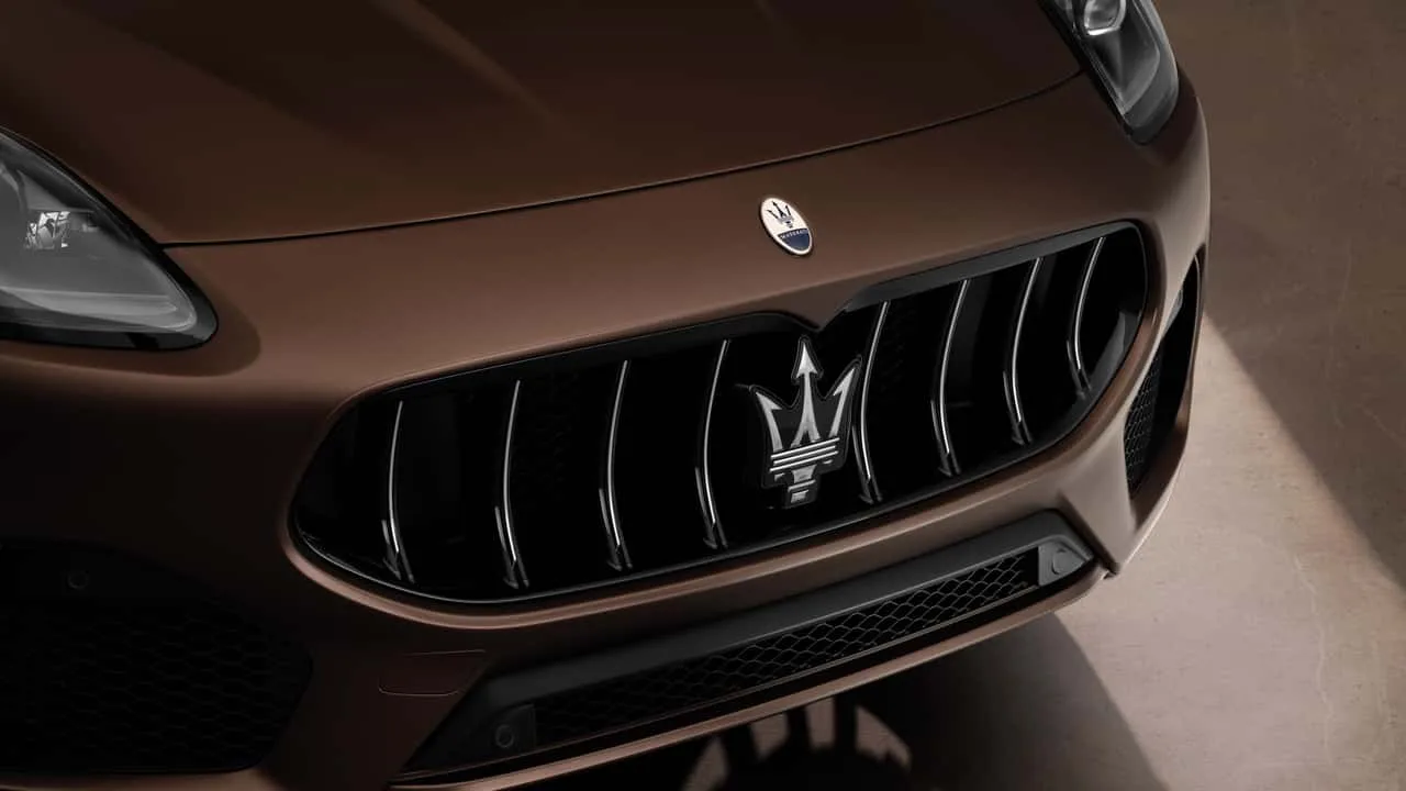 Detaliu al grilei Maserati cu logo-ul tridentului, simbol al tradiției italiene.