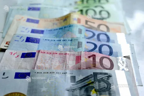 Bancnote euro aranjate pe o masă, simbolizând economia europeană.