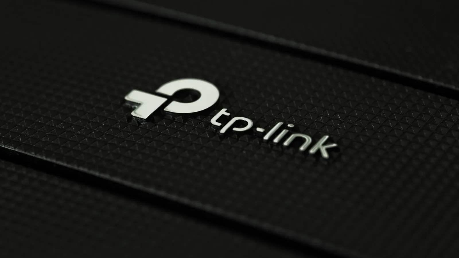 Logo TP-Link pe un fundal texturat, simbolizând inovația în tehnologie.