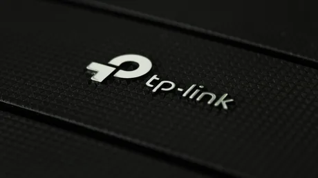 Logo TP-Link pe un fundal texturat, simbolizând inovația în tehnologie.