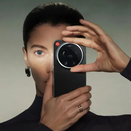 Un telefon Leica Leitzphone ținut de o persoană, evidențiind designul său elegant.