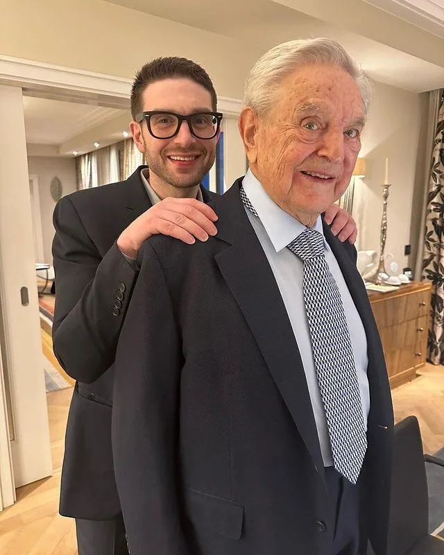 Alexander Soros și George Soros zâmbind într-un cadru familial.