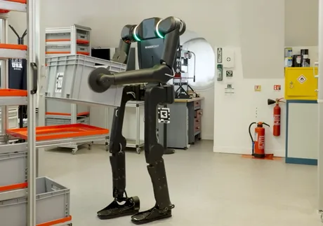 Robot umanoid ridicând o cutie într-o fabrică modernă.