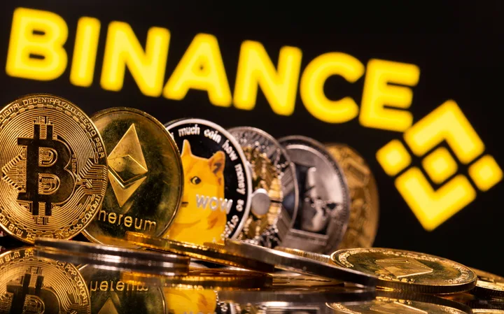 Monede cripto diverse, inclusiv Bitcoin, pe fundalul logo-ului Binance.