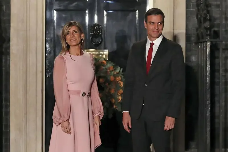 Begoña Gómez și Pedro Sánchez la o întâlnire oficială, cu un fundal elegant.