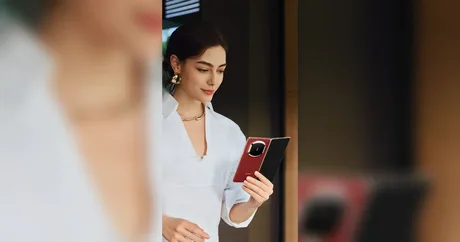 Un smartphone pliabil elegant, utilizat de o femeie într-un mediu modern.