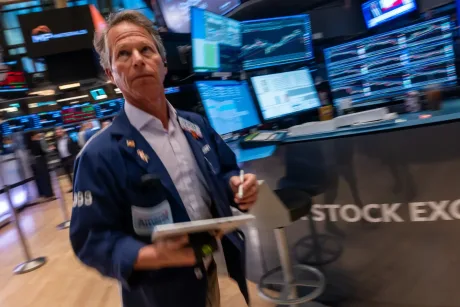 Trader pe piața de valori, analizând grafice și date financiare.