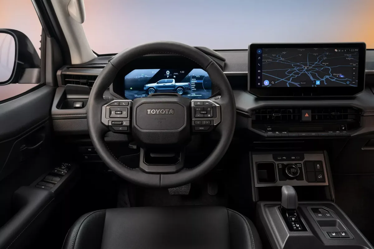 Interiorul noului Hilux electric cu ecrane moderne și volan ergonomic.