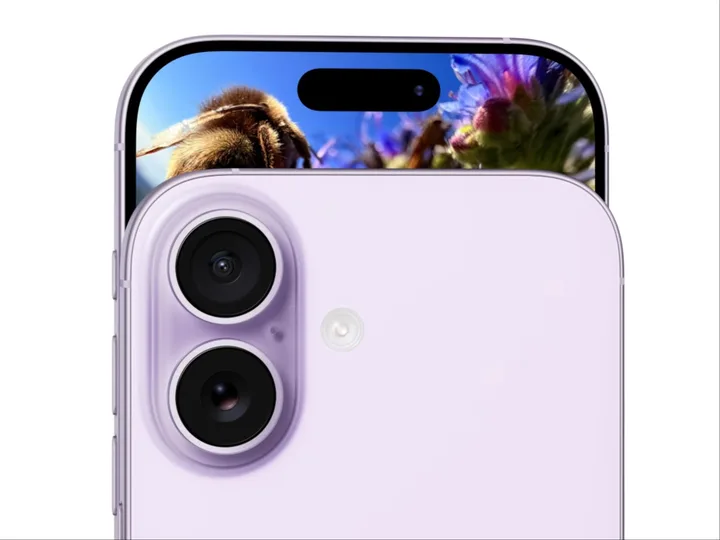 Detaliu al camerei unui smartphone modern, cu flori în fundal.
