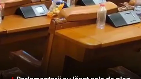 Deșeuri lăsate pe băncile din sala de plen după dezbateri bugetare.