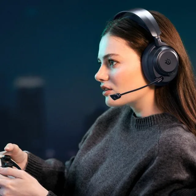 Tânără jucătoare folosind căști wireless pentru gaming, concentrată pe ecran.