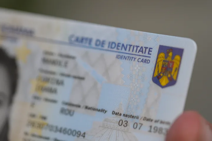 Detaliu al unei cărți de identitate românești, evidențiind designul și informațiile personale.