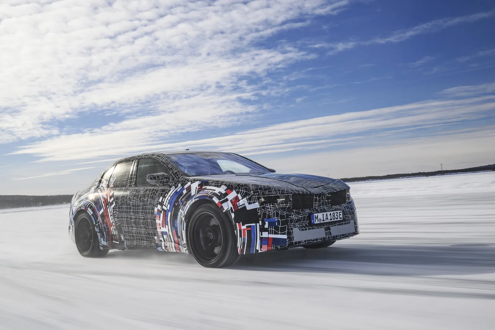 BMW M3 electric testat pe zăpadă, cu design camuflat și sunet artificial.