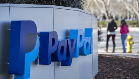 Logo-ul PayPal în fața clădirii companiei, cu oameni pe fundal.