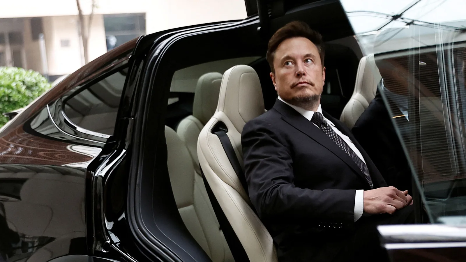 Elon Musk în mașină, reflectând asupra succesului recent.